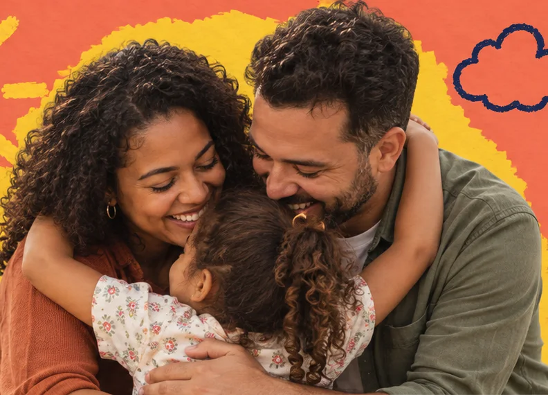 Mãe e pai abraçam uma menina, os três sorrindo.